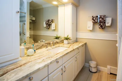 a bathroom with a granite countertop sink toilet and mirror