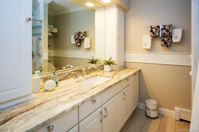 a bathroom with a granite countertop sink toilet and mirror
