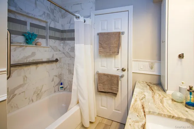 a bathroom with a tub sink and shower
