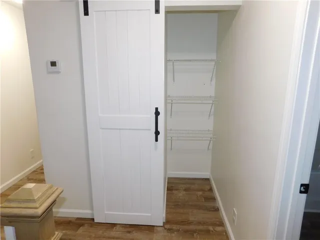 a view of room with walk in closet and wooden floor
