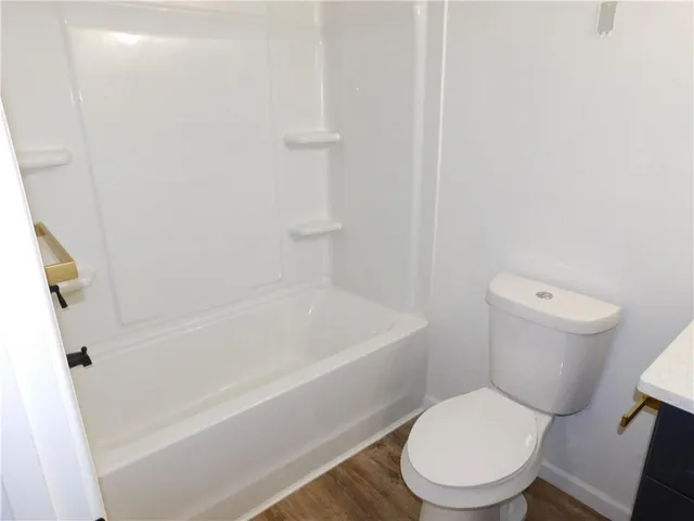a white toilet sitting next to a bath tub