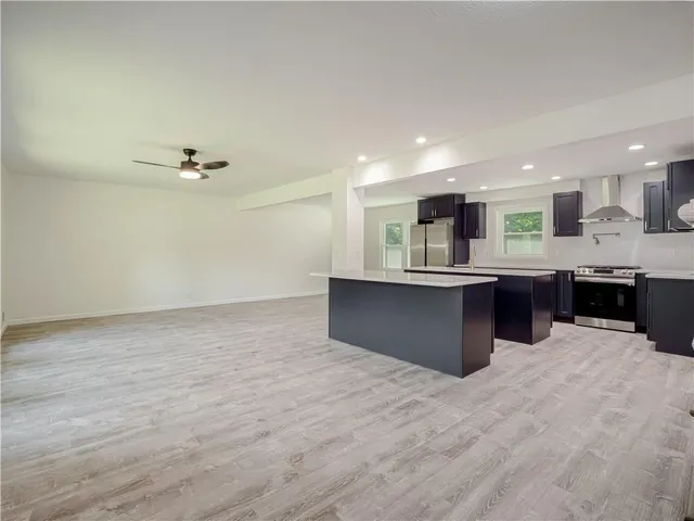 a large kitchen with stainless steel appliances kitchen island a sink dishwasher and a refrigerator