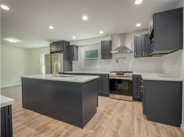 a kitchen with stainless steel appliances granite countertop a stove a sink and a refrigerator