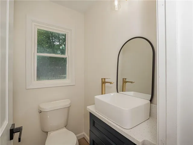 a bathroom with a toilet a sink and a window