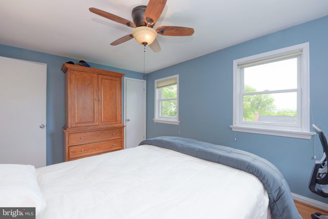 a bedroom with a large bed chandelier and a window