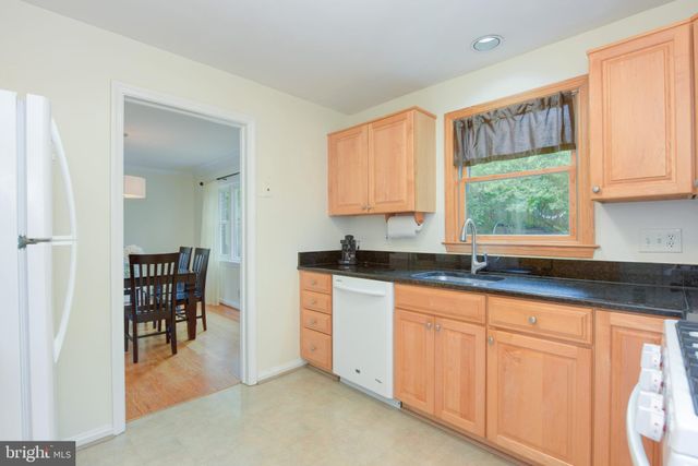 a kitchen with granite countertop a window and white cabinets