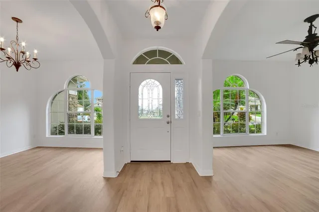 a view of a room with wooden floor fan and windows