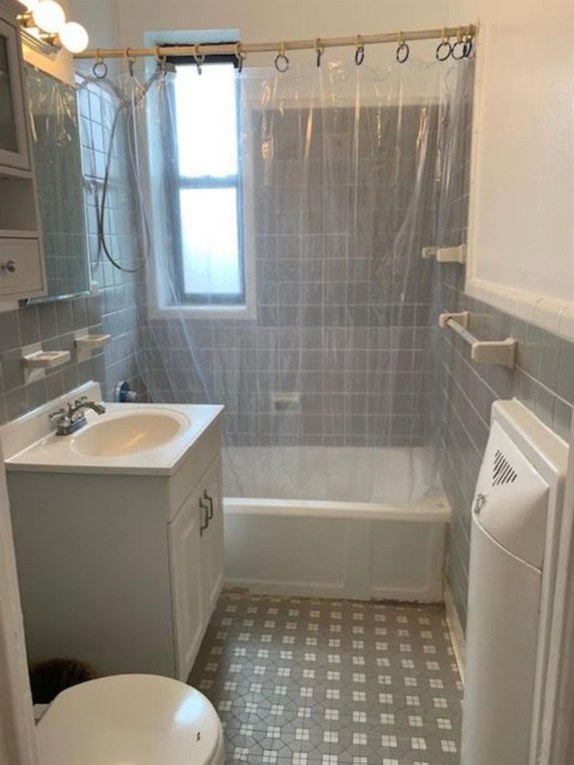 98-76 Queens Boulevard, Unit 6L Queens, NY 11374 - Photo 5 of 5 Full bath with tile walls, vanity, and shower / tub combination