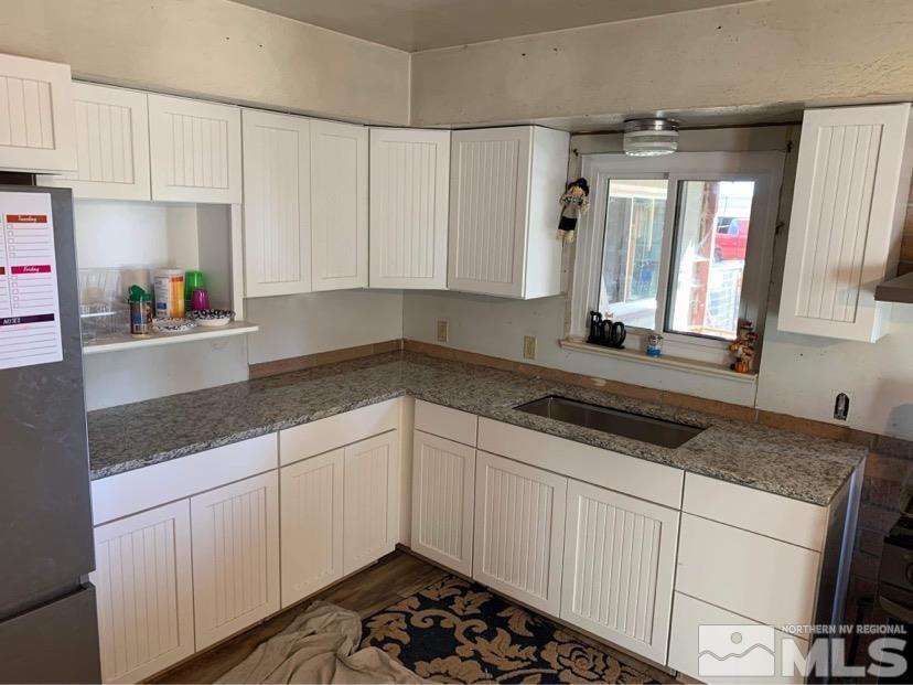 2975 Lone Tree Road Fallon, NV 89406 - Photo 5 of 26 a kitchen with granite countertop a sink stove and cabinets