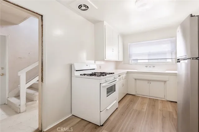 a kitchen with white cabinets and white appliances