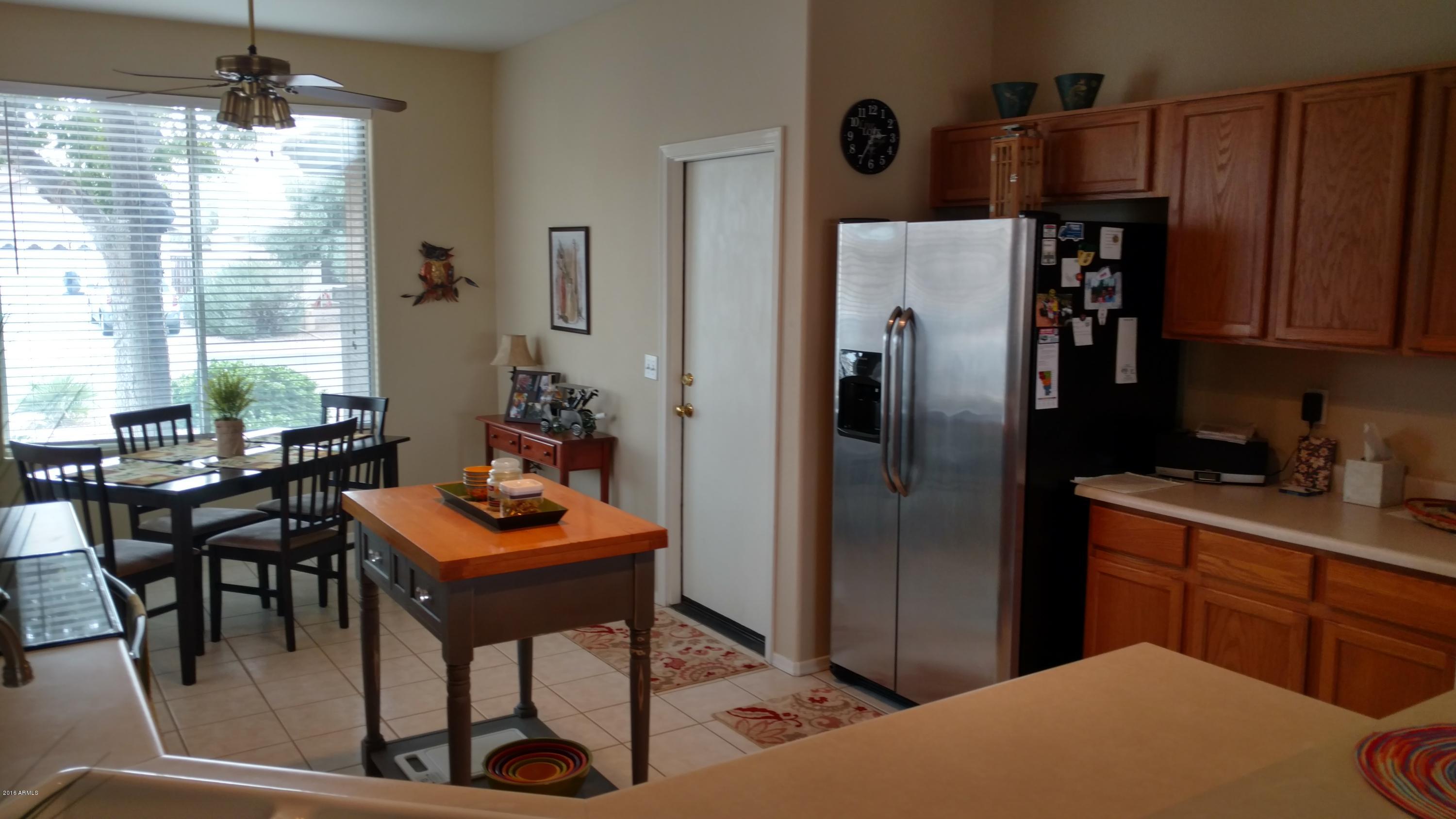 44 West Del Rio Street Gilbert, AZ 85233 - Photo 3 of 21 a kitchen with stainless steel appliances granite countertop a refrigerator and a table