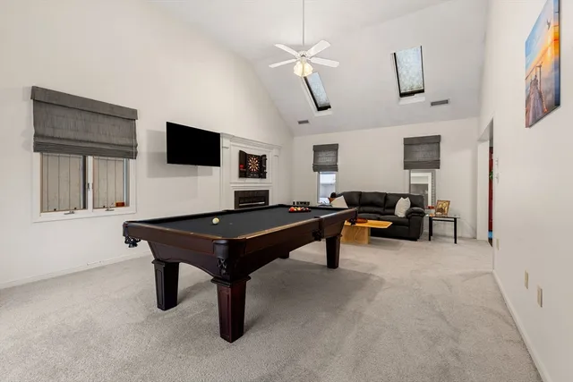 a living room with furniture a flat screen tv and kitchen view