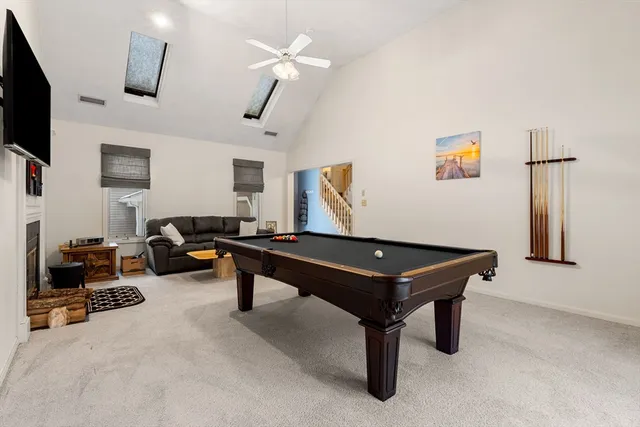 a room with furniture pool table and flat screen tv
