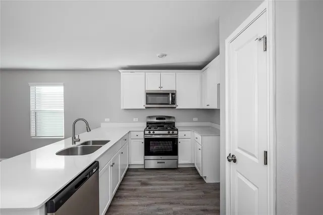 a kitchen with sink a stove and cabinets