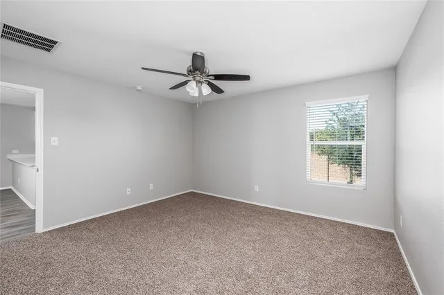 a view of a livingroom with a ceiling fan and window