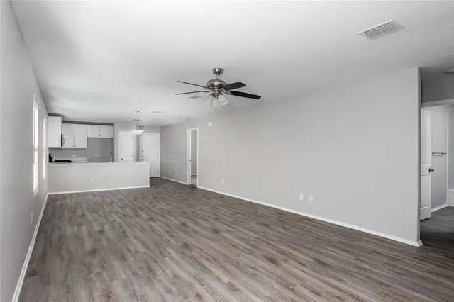 a view of a livingroom with a hardwood floor and a ceiling fan