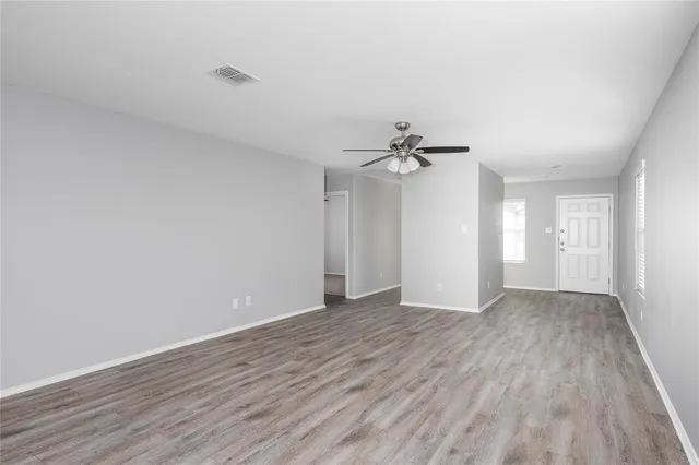 a view of an empty room with wooden floor