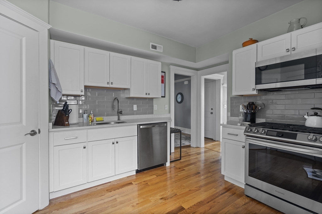 40 King Street, Unit 3 Boston, MA 02122 - Photo 4 of 14 a kitchen with stainless steel appliances granite countertop a stove a sink and a microwave