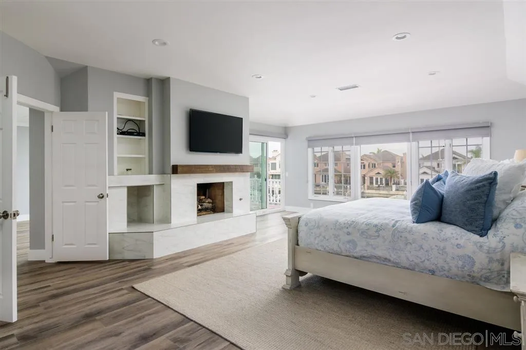 9 Buccaneer Way Coronado, CA 92118 - Photo 14 of 23 a spacious bedroom with a large bed a flat tv screen and a fireplace