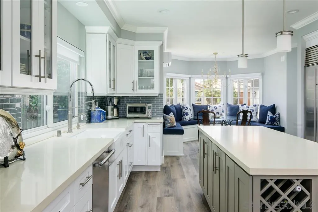 9 Buccaneer Way Coronado, CA 92118 - Photo 9 of 23 a large white kitchen with kitchen island a stove a sink a refrigerator and dishwasher with wooden floor