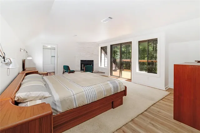 a spacious bedroom with a bed and wooden floor
