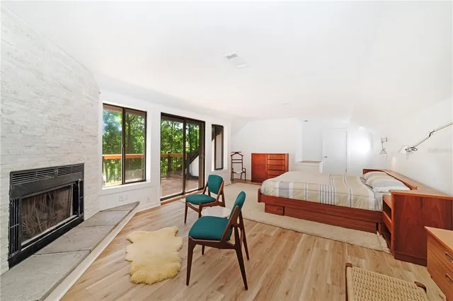 a spacious bedroom with a bed a fireplace and a large window