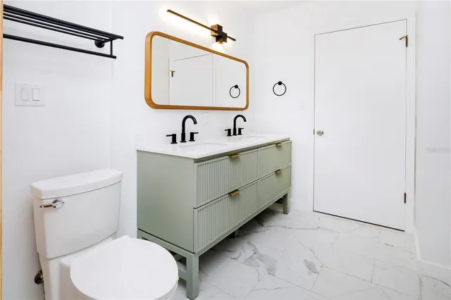 a white toilet sitting next to a bathroom sink