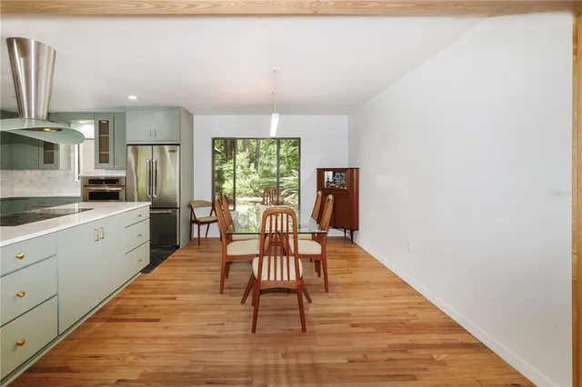 a kitchen with granite countertop wooden floor a dining table and chairs