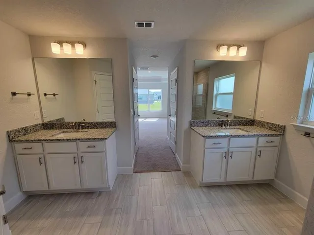 a bathroom with a granite countertop sink and a mirror