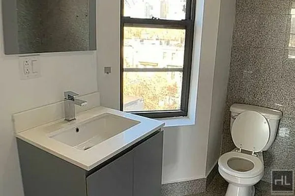 a bathroom with a sink toilet and a mirror