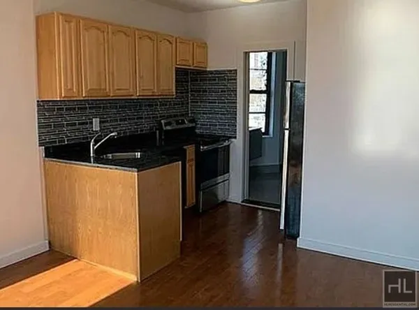 a kitchen with granite countertop a refrigerator and a stove top oven