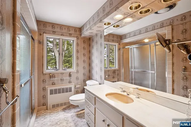 a bathroom with a sink toilet double vanity and shower