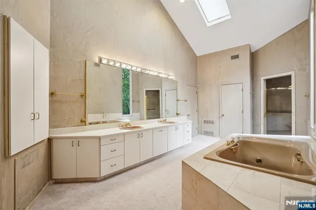 a bathroom with a granite countertop sink mirror and bathtub