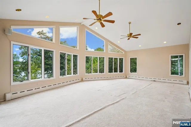 a view of an empty room with a window and a ceiling fan