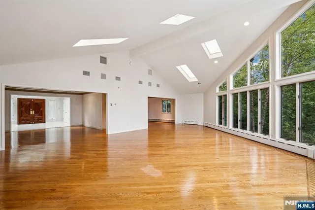 a view of empty room with wooden floor and windows