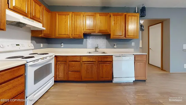 a kitchen with stainless steel appliances a stove a refrigerator a dining table and chairs