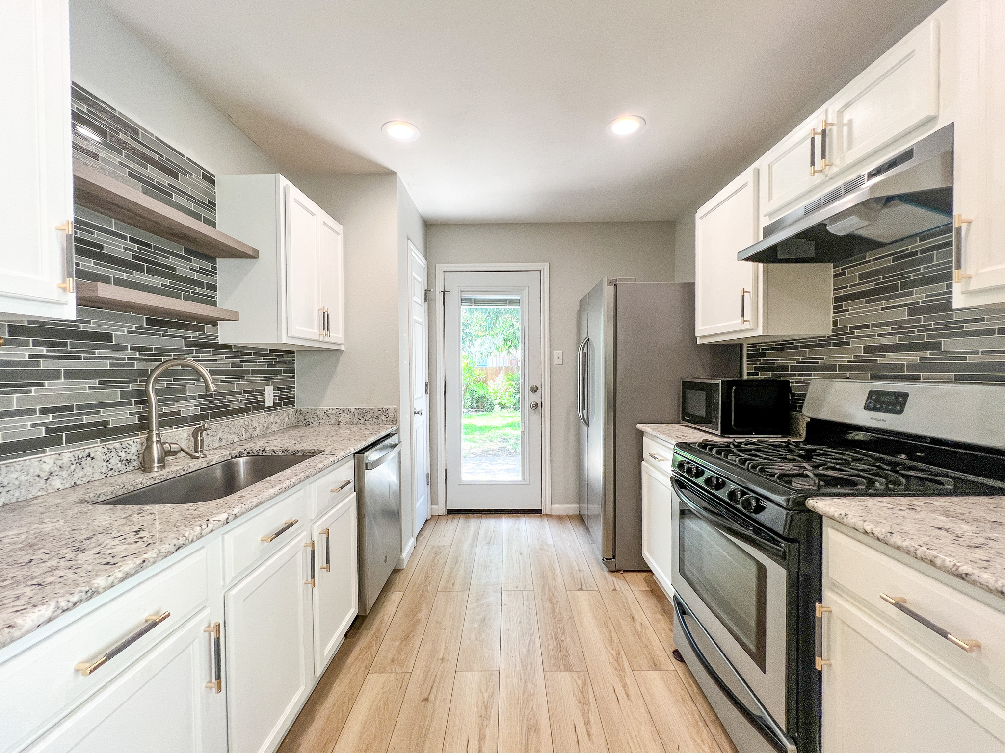 298 Jack Rabbit Lane Buda, TX 78610 - Photo 5 of 24 Culinary delights await in this modern galley kitchen featuring sleek counters and ample cabinetry.