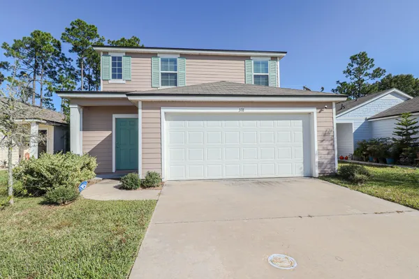 a front view of a house with a yard and garage