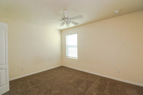 an empty room with a ceiling fan and a window