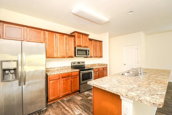 a kitchen with stainless steel appliances granite countertop a sink stove and refrigerator