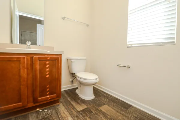a bathroom with a toilet a sink and a window