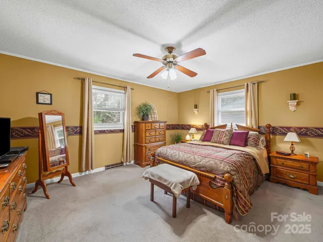 a spacious bedroom with a bed a dresser and a flat screen tv