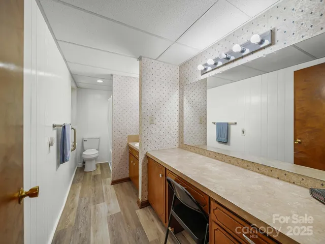 a spacious bathroom with a sink a large mirror and a toilet