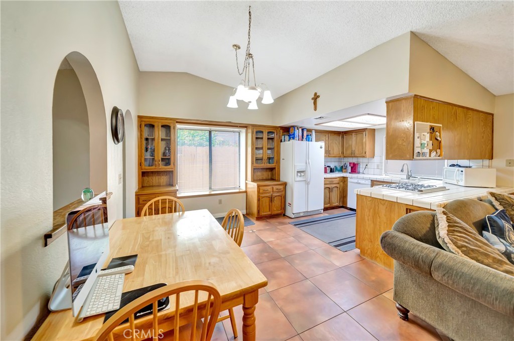 729 North Sunland Drive Ridgecrest, CA 93555 - Photo 13 of 52 a living room with furniture dining table and a refrigerator