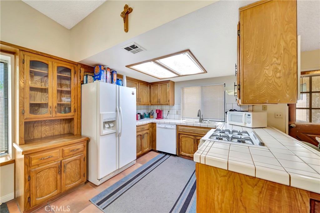 729 North Sunland Drive Ridgecrest, CA 93555 - Photo 14 of 52 a kitchen with a refrigerator and a stove top oven