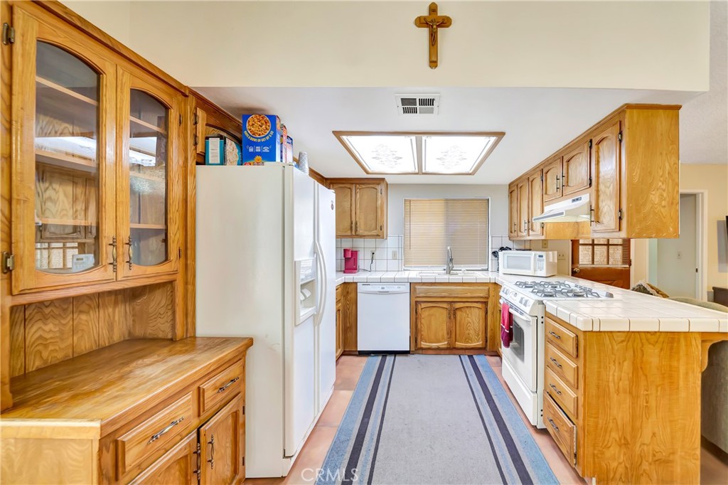 729 North Sunland Drive Ridgecrest, CA 93555 - Photo 15 of 52 a kitchen with a refrigerator a stove top oven a sink and dishwasher
