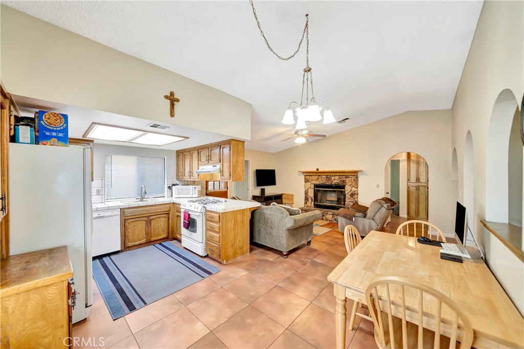 729 North Sunland Drive Ridgecrest, CA 93555 - Photo 19 of 52 a open kitchen with stainless steel appliances granite countertop a sink dishwasher stove a refrigerator with a dining table and chairs with wooden floor
