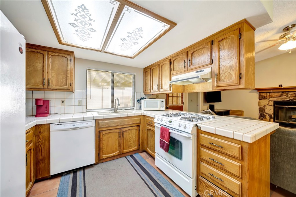 729 North Sunland Drive Ridgecrest, CA 93555 - Photo 20 of 52 a kitchen with a stove a sink and a refrigerator