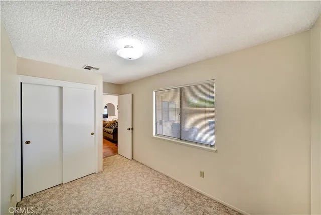 an empty room with windows and closet