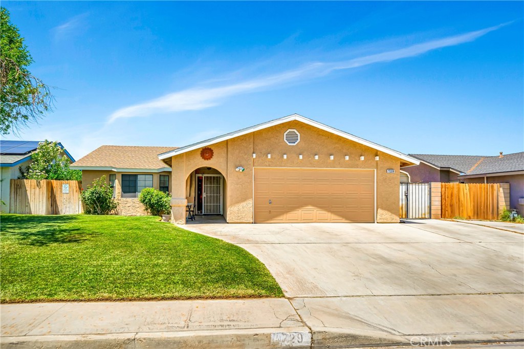 729 North Sunland Drive Ridgecrest, CA 93555 - Photo 3 of 52 a front view of a house with a yard and garage
